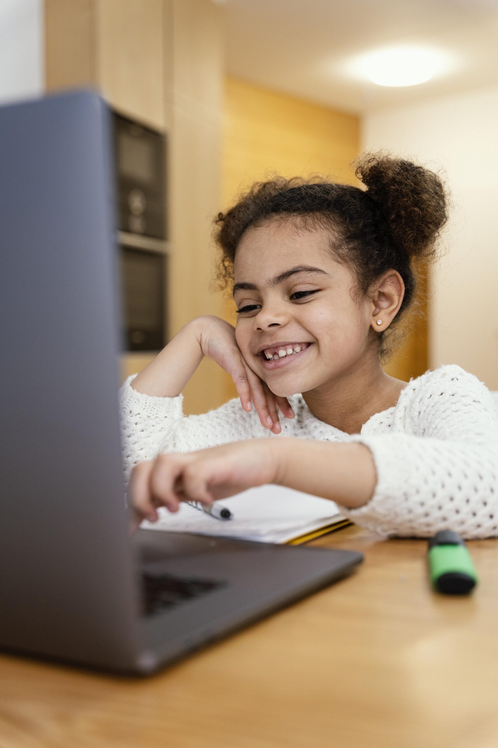 happy little girl home during online school with laptop 1 scaled