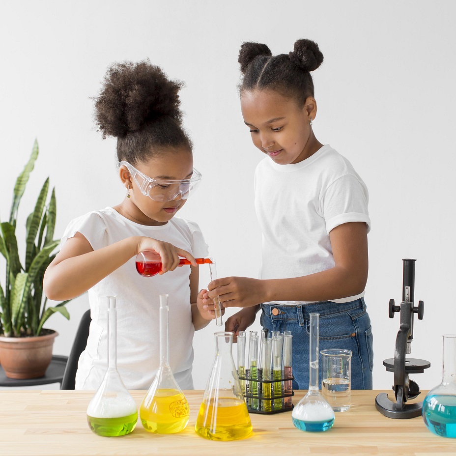 two girls with safety glasses experimenting with science